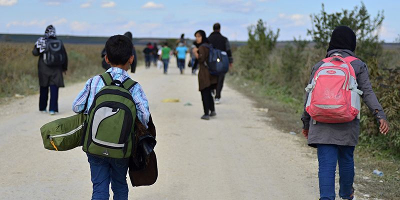 a group of refugees walking along a road